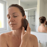 Femme utilisant la brosse sur la pommette