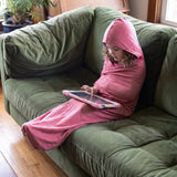 Enfant dans le Lumea Cocon rose, capuche relevee, avec sa tablette